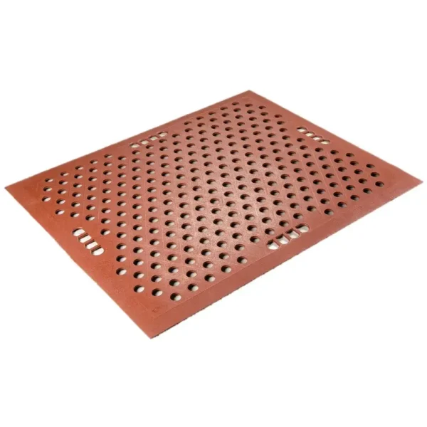 The Food Production Mat is a rectangular red rubber mat featuring evenly spaced circular holes and several wider rectangular cut-outs, designed to provide drainage and traction on floors.