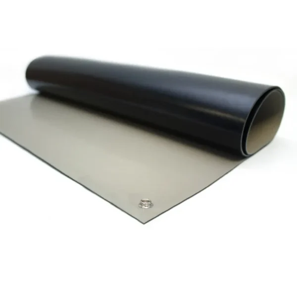 A partially unrolled ESD Bench Mat in black and grey rests on a flat surface, featuring a visible metal snap connector near one corner.