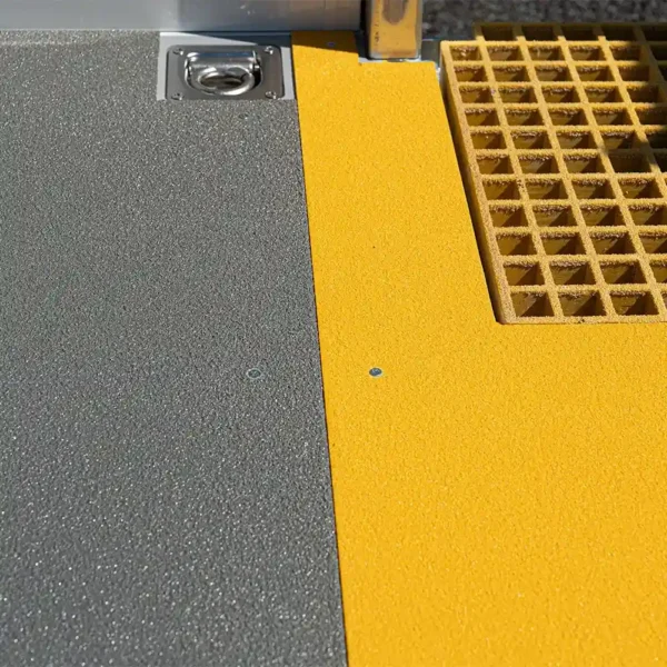 Close-up of an Anti-Slip Flat Sheet with a textured grey surface beside a yellow textured section, featuring a yellow grid mat inset and a metal fitting in the top left corner.
