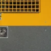Close-up of the Anti-Slip Flat Sheet, showing its yellow and grey surface with a metal grid vent above and a round metallic component with a small screw on the lower left.