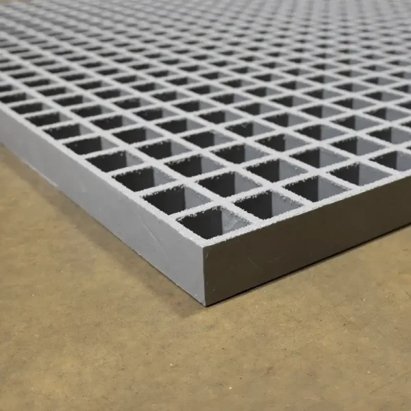 A close-up of the Open Top Grating shows its sturdy, industrial metal grid with square openings, placed on a smooth brown surface.