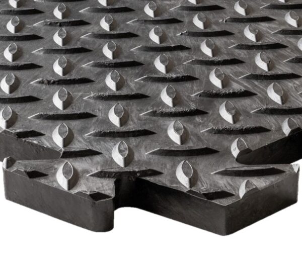 Close-up of a Chequer Plate Interlocking Tile, featuring a black rubber surface with a raised diamond pattern, leaf-shaped grips, and an interlocking edge design.